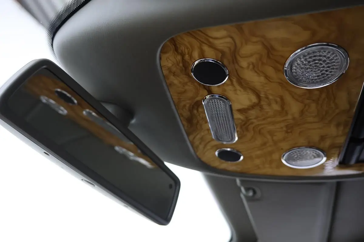 Détail du plafonnier en bois verni avec éclairages intégrés et miroir intérieur d'une Bentley Continental Flying Spur.