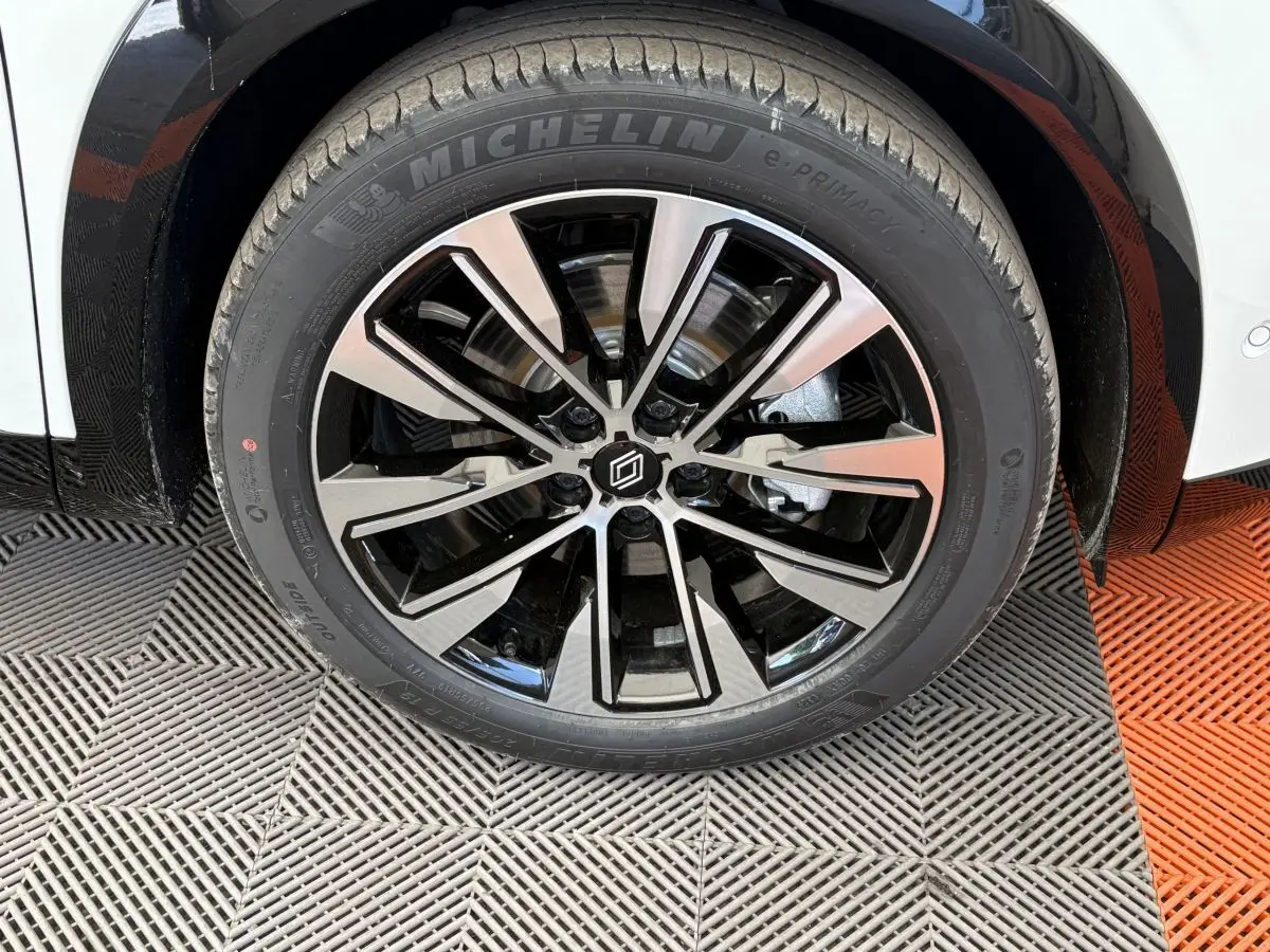 Gros plan sur la roue avant droite blanche du Renault Austral 2025 avec jante alliage noir et argent Michelin e-Primacy.