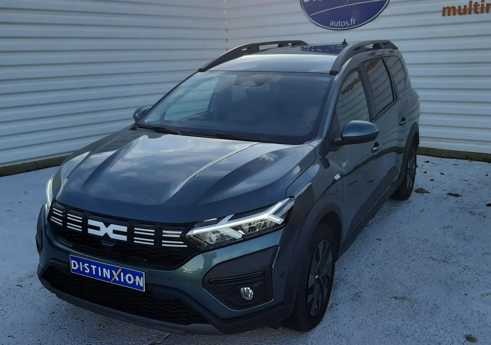 Vue latérale gauche d'un Dacia Jogger 2025 vert cèdre métal avec jantes noires et toit noir.