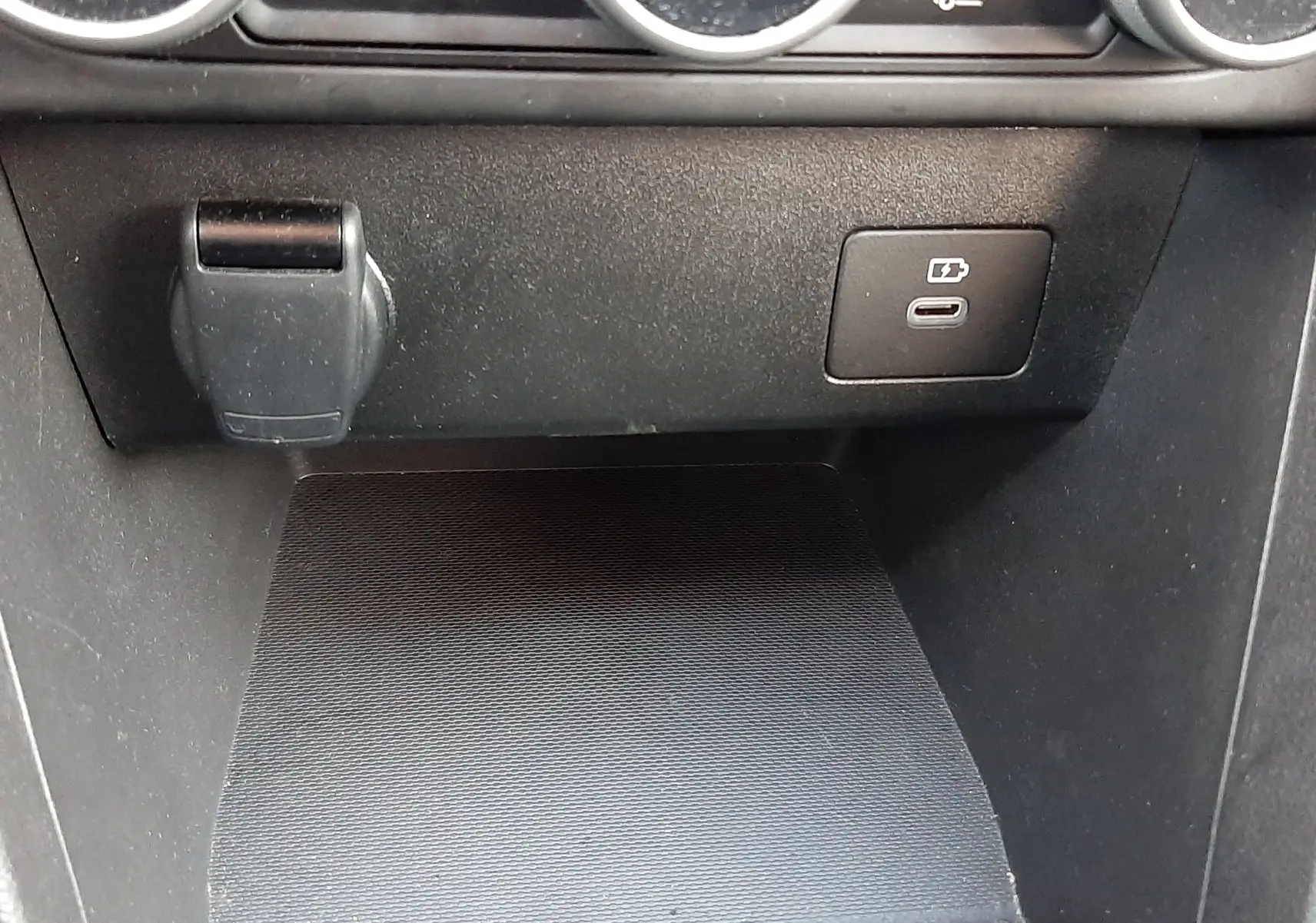 Détail de la console centrale du Dacia Jogger 2025 montrant une prise USB-C et un port 12V sous les commandes de climatisation.