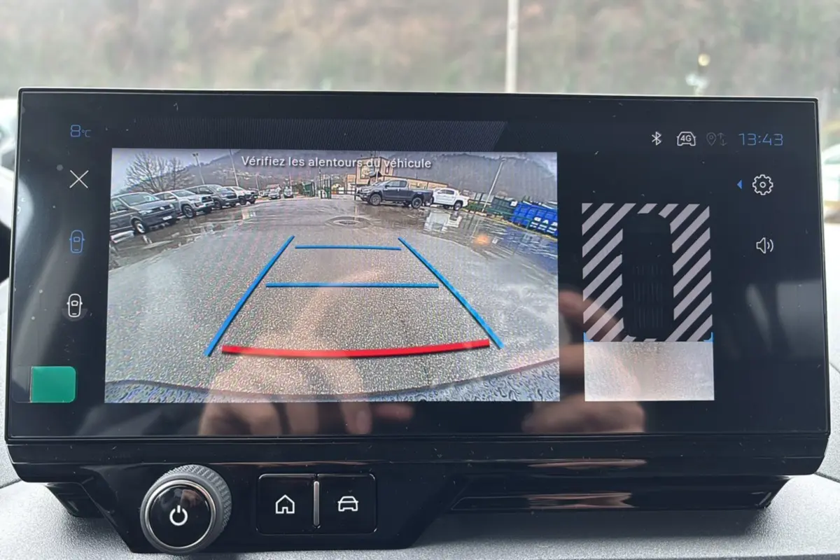 Écran tactile du Peugeot Rifter BlueHDi 130 montrant la caméra de recul avec guidage coloré en extérieur.