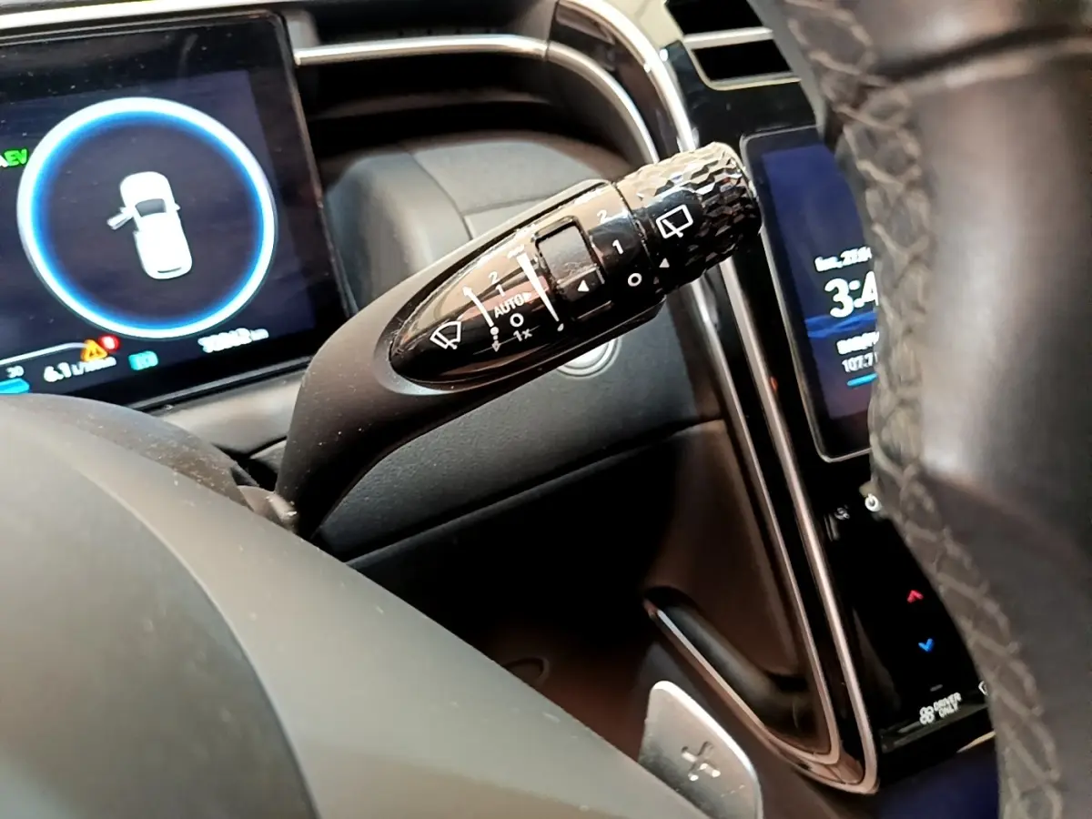 Gros plan sur la commande d’essuie-glace à gauche du volant cuir du Hyundai Tucson 1.6 Hybrid 230 gris foncé 2022.