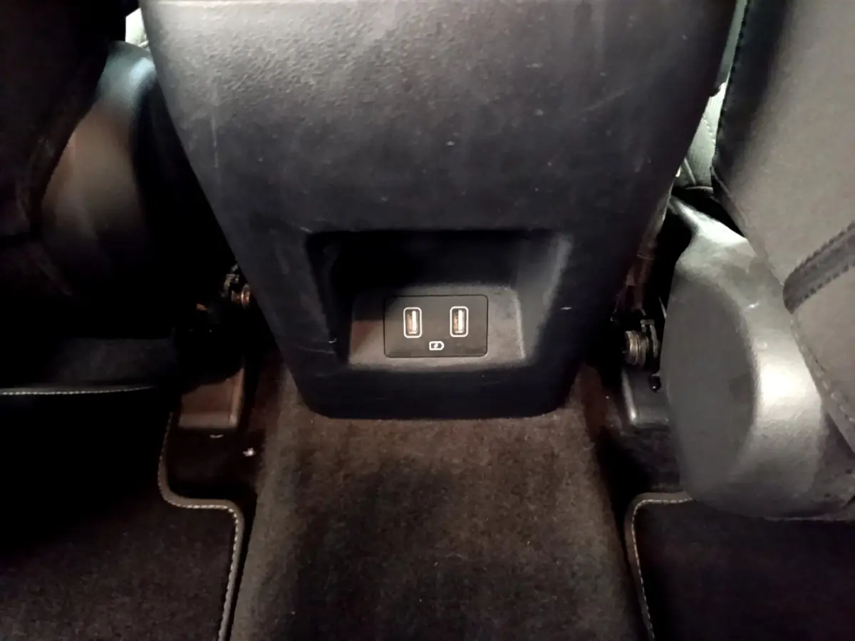 Vue intérieure du Hyundai Tucson 1.6 Hybrid 230 Creative 2022, prise du sol montrant la prise USB double à l'arrière de la console centrale.
