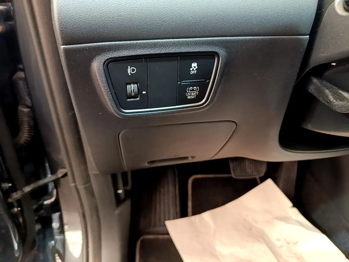 Vue intérieure côté conducteur du Hyundai Tucson 1.6 Hybrid 230 gris foncé, avec commandes d’éclairage et stabilité.
