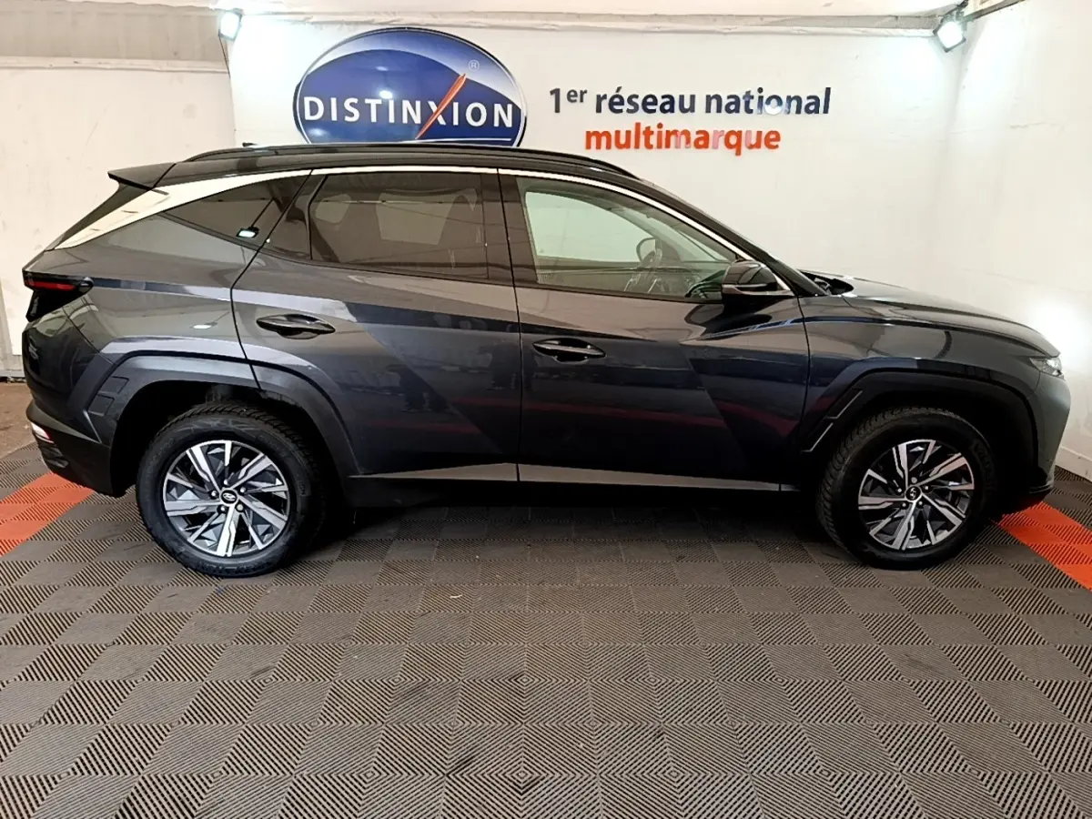 Profil droit du Hyundai Tucson 1.6 Hybrid 230 Creative gris foncé, avec jantes alliage et vitres teintées.