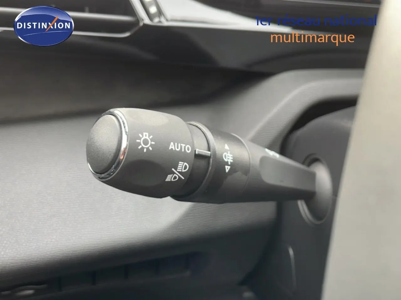 Gros plan sur la commande des phares automatiques dans l’habitacle d’une Peugeot 308 gris selenium 2026.