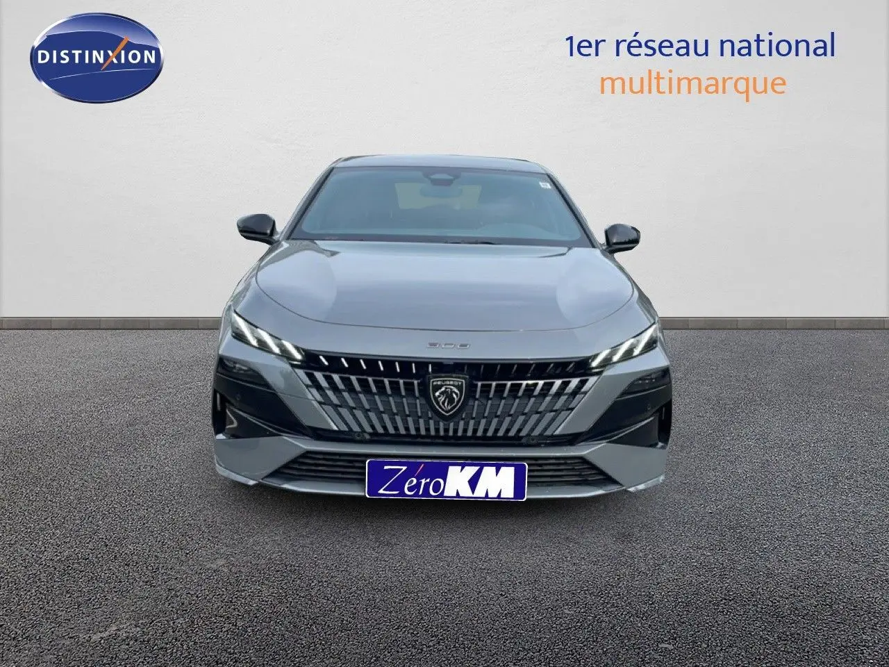 Vue de face d'une Peugeot 308 gris selenium metal, mettant en valeur sa calandre distinctive et ses phares LED fins.
