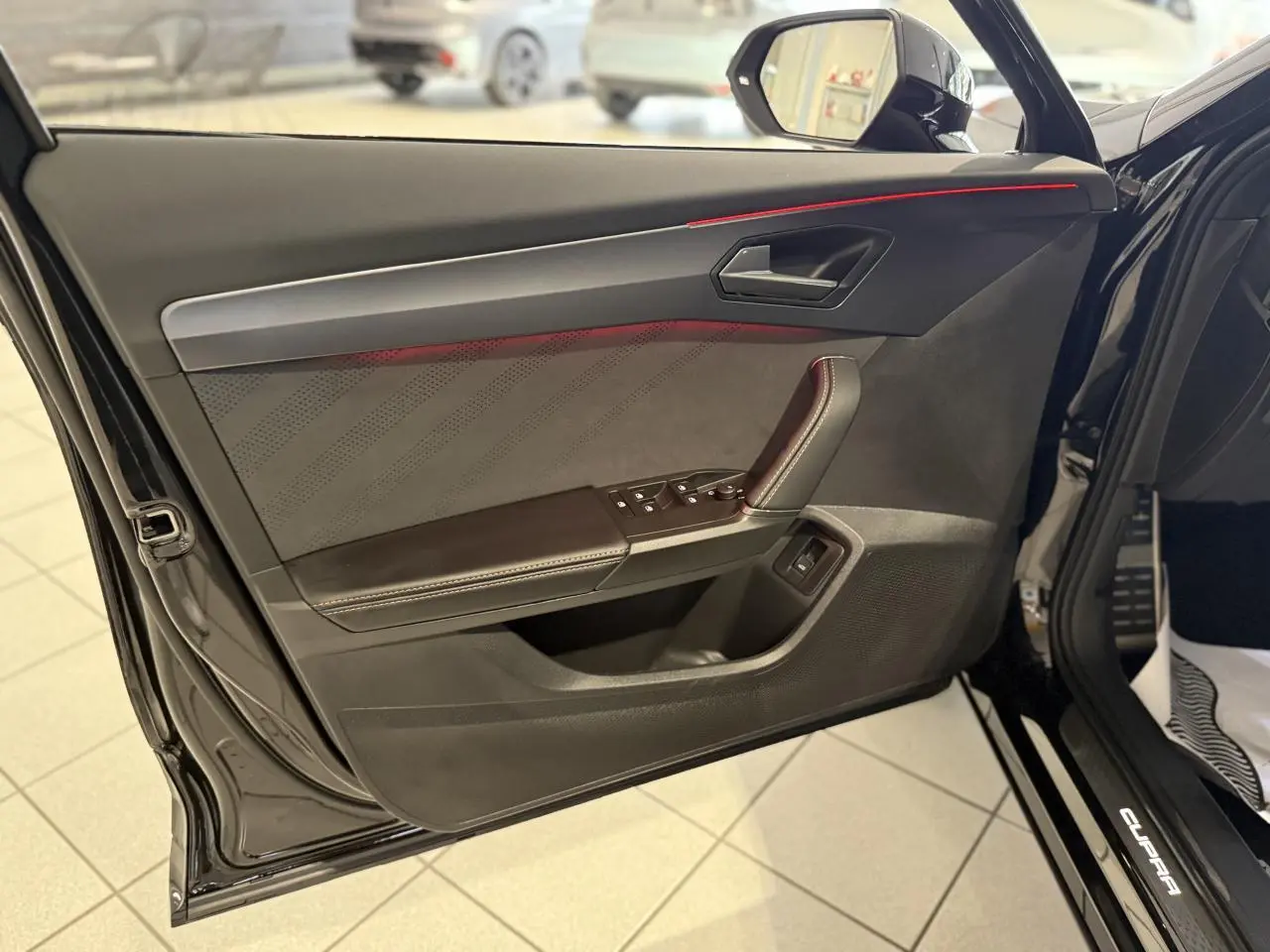 Contre-porte avant gauche noir avec surpiqûres cuivrées et poignée intégrée, intérieur d’une CUPRA Formentor 2025.