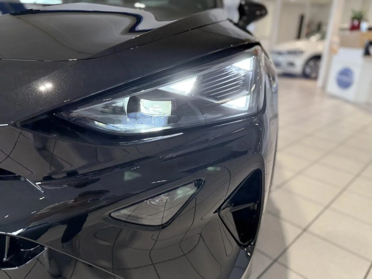Gros plan sur l'avant droit noir Night du CUPRA Formentor 2025 avec phare LED triangulaire allumé.