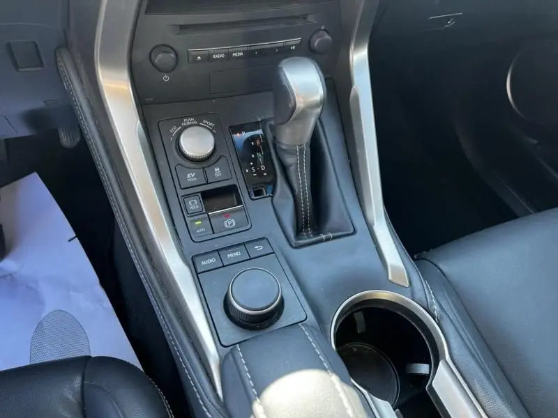 Vue rapprochée de la console centrale du Lexus NX 300H 2WD Sport Edition avec levier de vitesses et commandes en cuir noir.
