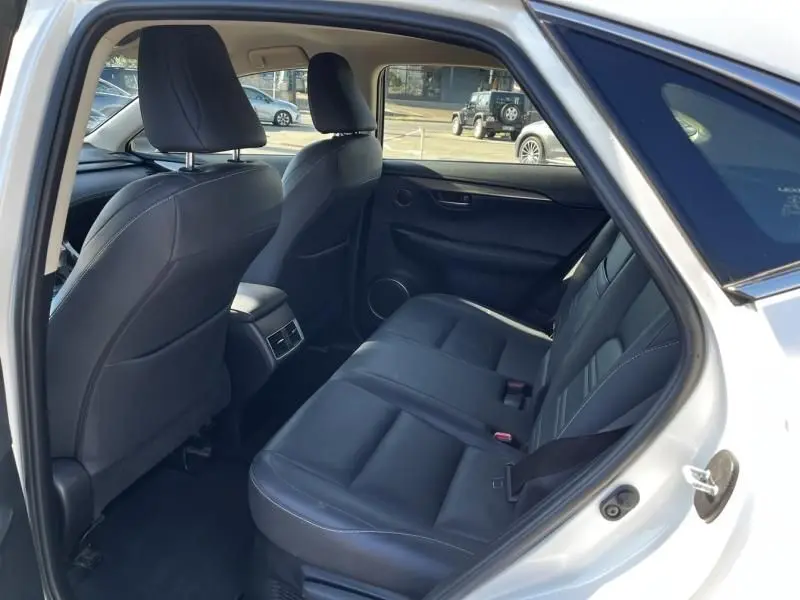 Vue intérieure arrière côté droit du Lexus NX 300H blanc nacré, sièges en cuir noir et console centrale avec aérateurs.