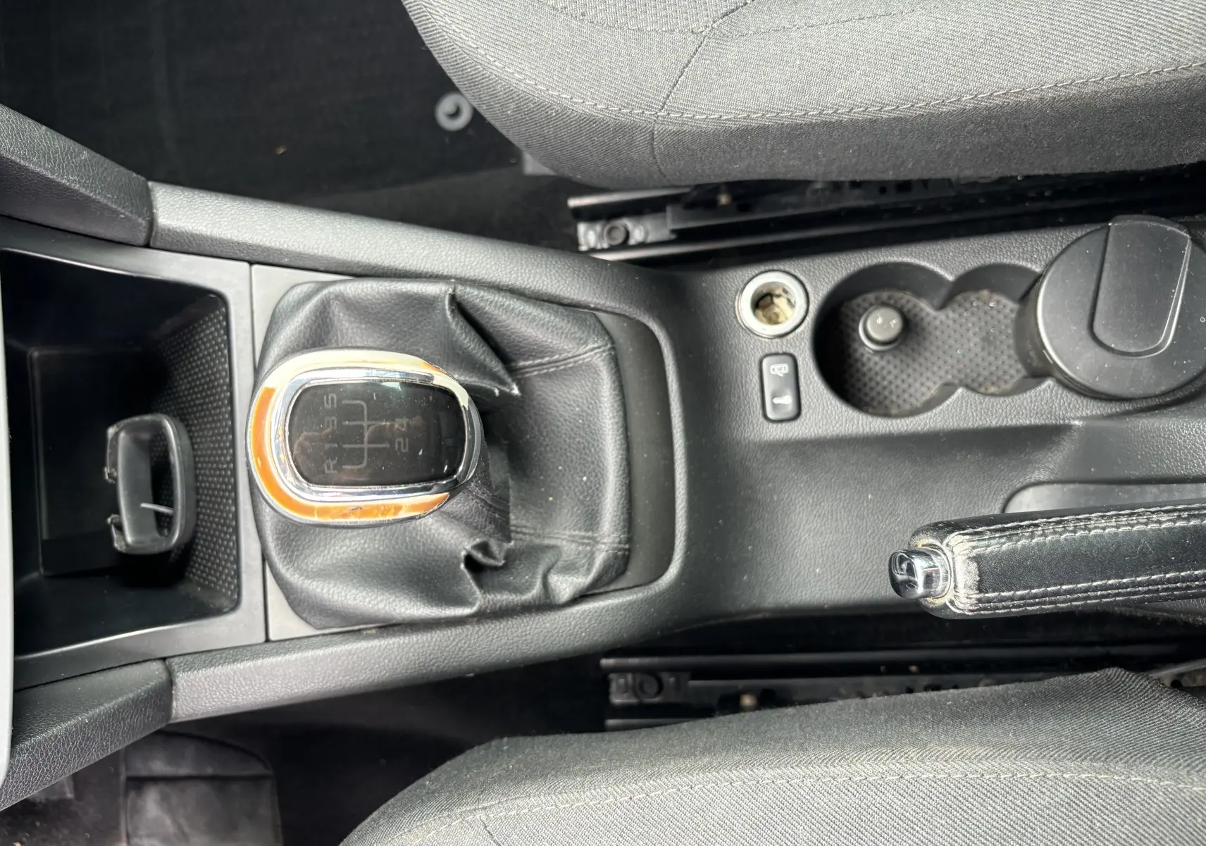 Vue plongeante sur la console centrale du Skoda Yeti gris, mettant en valeur le levier de vitesses manuel et le frein à main cuir.