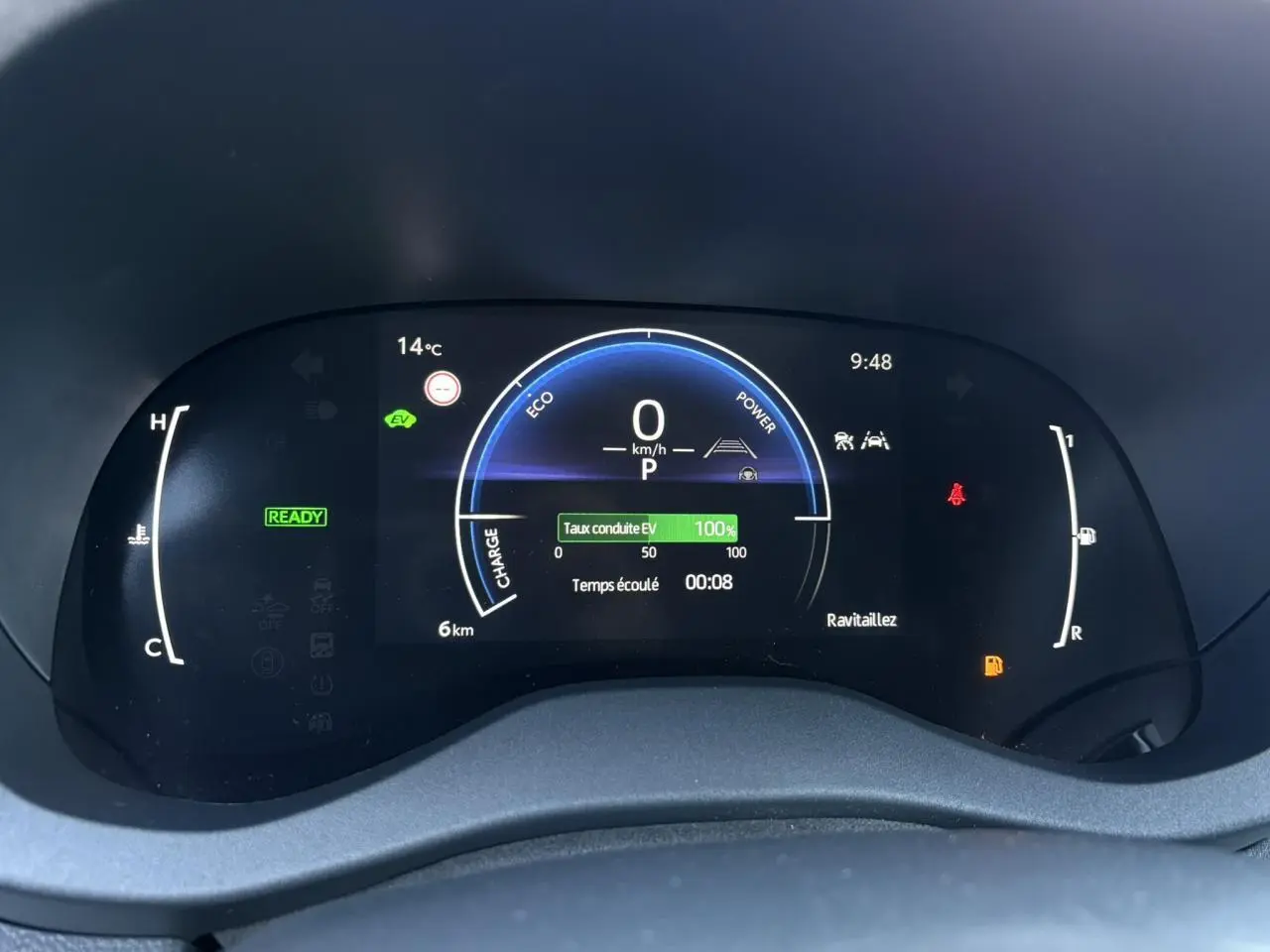 Tableau de bord numérique de la Toyota Yaris Hybride 2025 affichant vitesse, température et indicateurs de conduite EV.