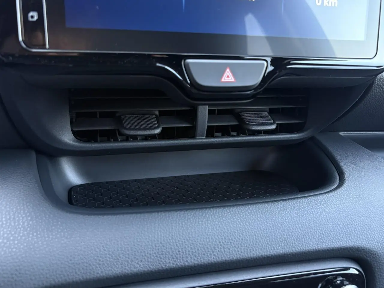 Détail de la console centrale noire de la Toyota Yaris hybride 2025 avec écran tactile et commandes d'aération visibles.