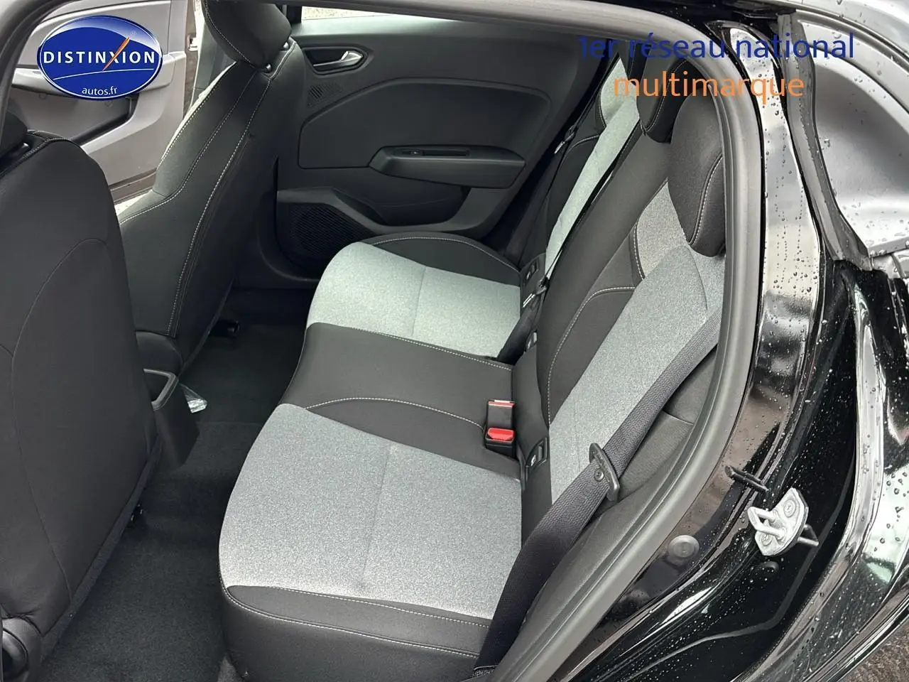 Vue intérieure côté droit sur la banquette arrière bi-ton gris et noir de la Renault Clio V noir étoilé 2025.