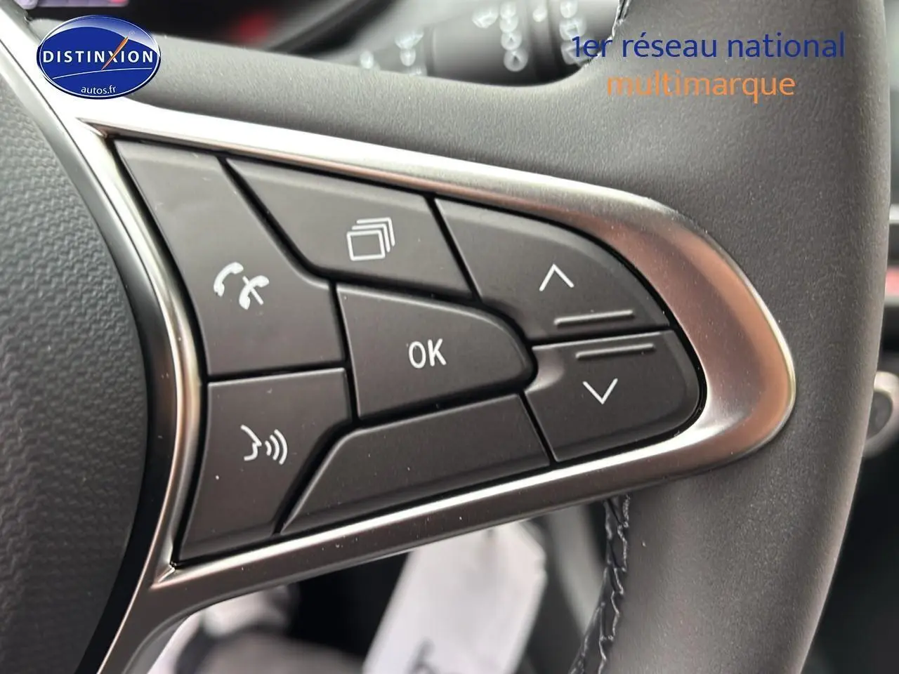 Gros plan sur les commandes multifonctions du volant cuir d'une Renault Clio V noire étoilé, avec boutons de navigation et appel.