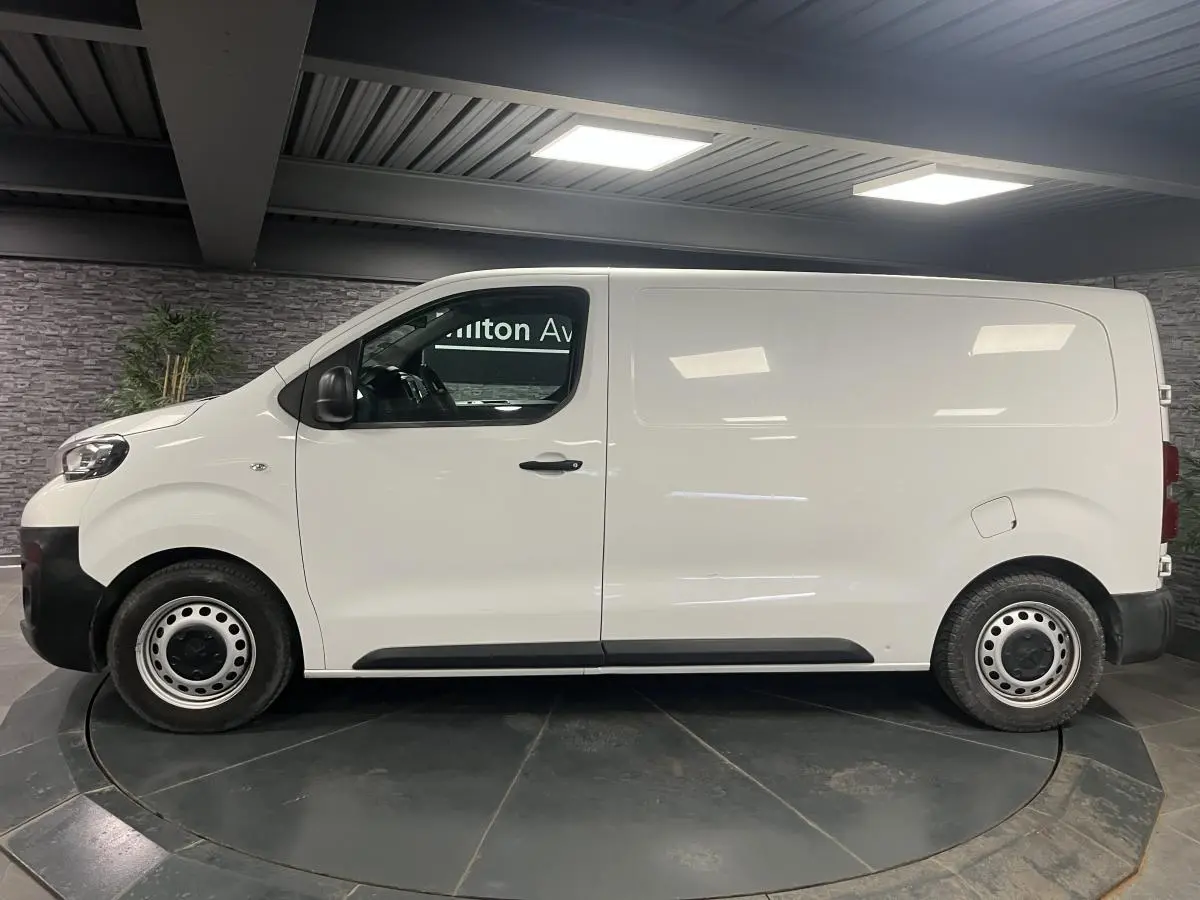 Profil côté gauche d'un Peugeot Expert Fourgon blanc 2020 avec portes tôlées et roues tôle noires.