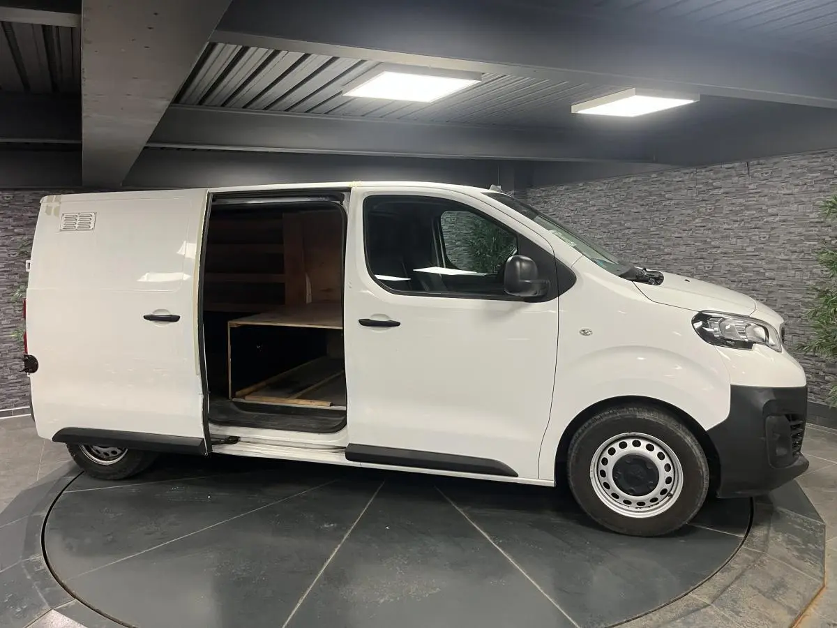 Peugeot Expert Fourgon blanc vu de profil droit, porte latérale coulissante ouverte montrant l'intérieur bois.