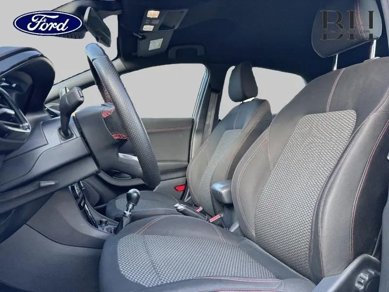 Intérieur avant du Ford Puma 1.0 EcoBoost 2021 avec sièges sport noirs à surpiqûres rouges et volant multifonction.