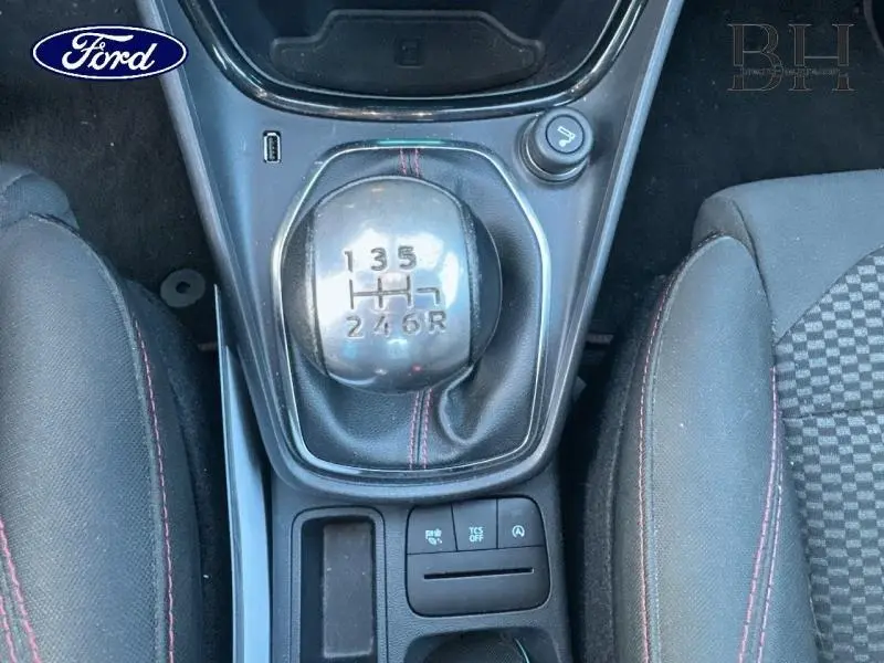 Gros plan sur levier de vitesses manuel et console centrale noire avec coutures rouges dans Ford Puma gris Fashion Métallisé.