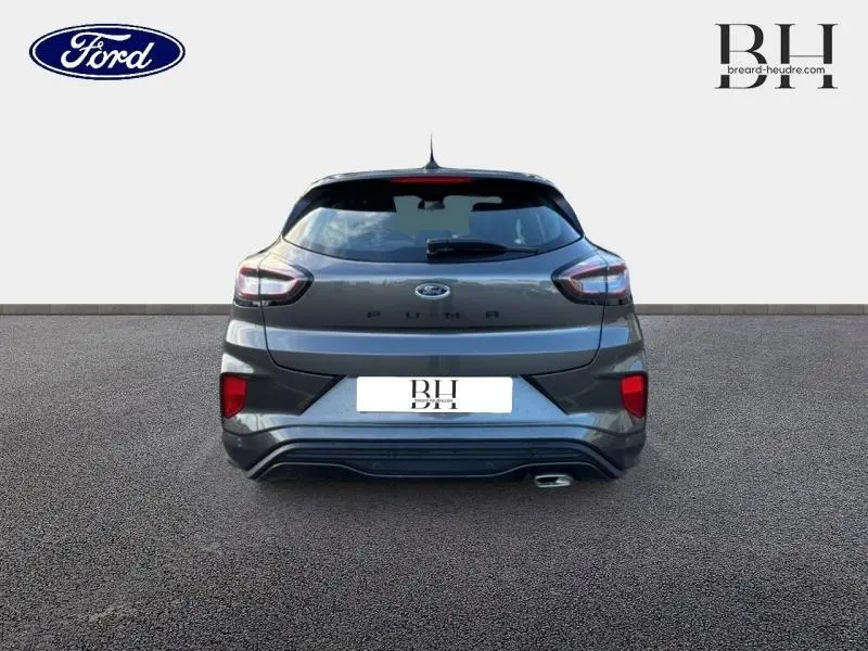 Vue arrière d'une Ford Puma 1.0 EcoBoost 125ch mHEV ST-Line gris métallisé avec feux LED et sortie d'échappement chromée.