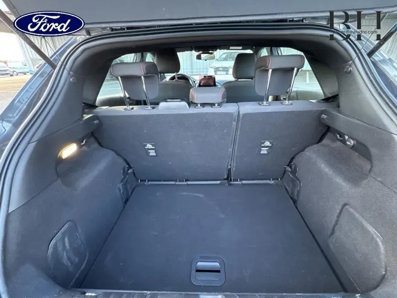 Coffre ouvert du Ford Puma gris Fashion, vue arrière montrant la banquette rabattable et l'espace de chargement noir.