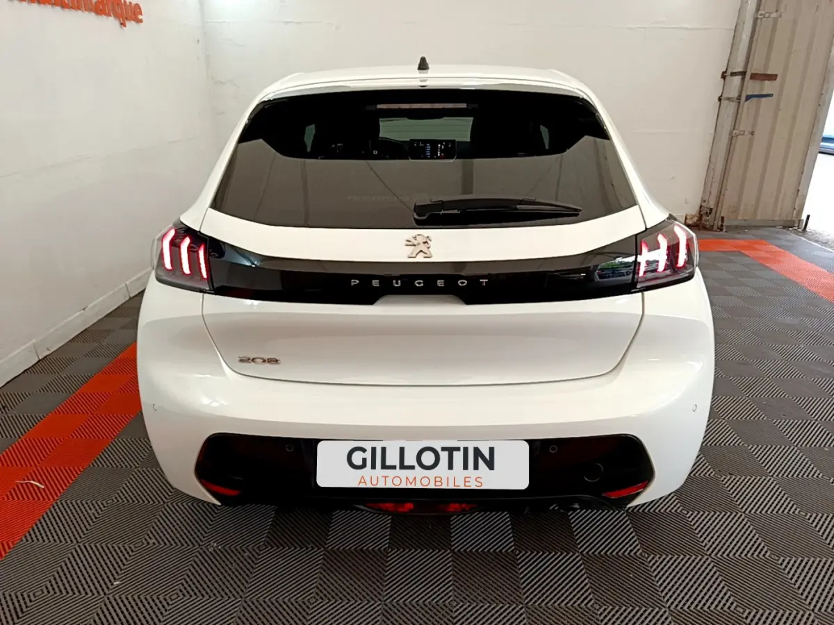 Vue arrière d'une Peugeot 208 blanche de 2020 avec feux LED caractéristiques et logo Peugeot centré sur le hayon.
