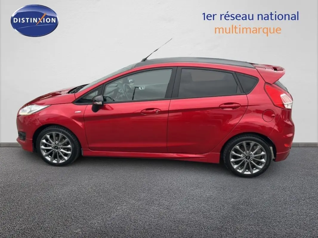 Vue latérale droite d'une Ford Fiesta rouge 2017 avec jantes alliage et vitres surteintées.