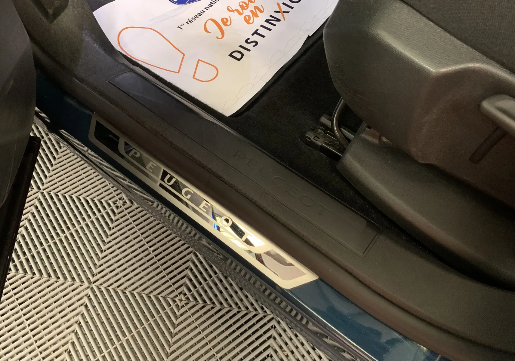 Gros plan sur les commandes des vitres électriques et réglages des rétroviseurs côté gauche intérieur d'un Peugeot 3008 bleu Celebes.