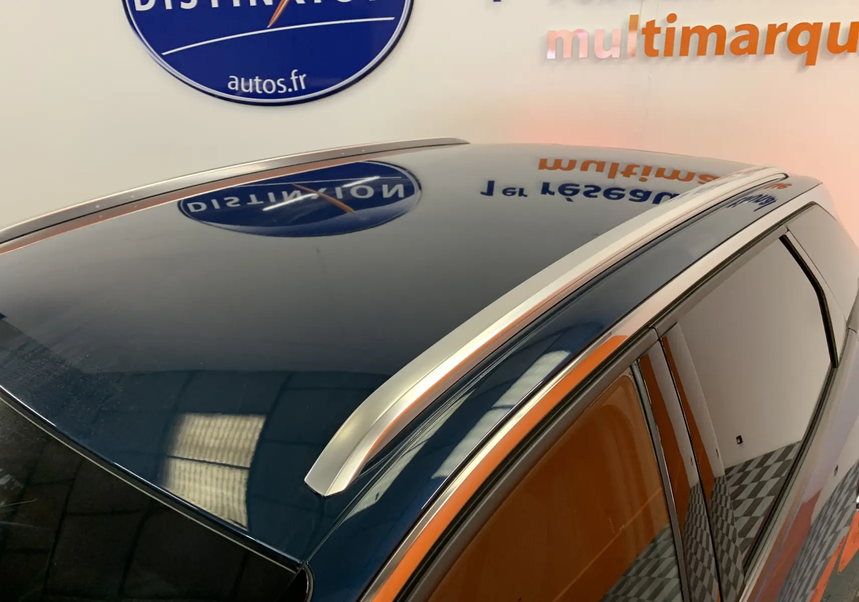 Toit panoramique et barres de toit argentées sur un Peugeot 3008 bleu Célèbes vu de dessus côté droit.