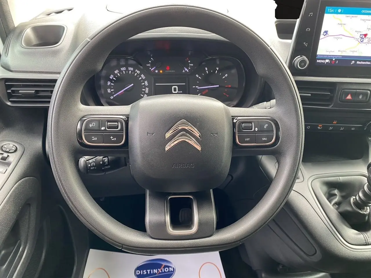 Vue centrée sur le volant noir du Citroën Berlingo 2019, avec tableau de bord et écran GPS visible à droite.