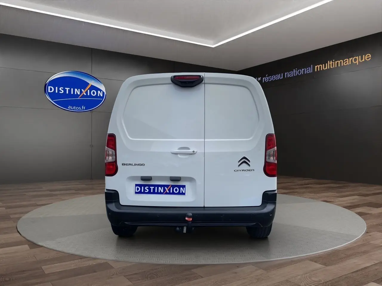Vue arrière d'un Citroën Berlingo blanc 2019 avec hayon double et attelage visible en intérieur showroom.