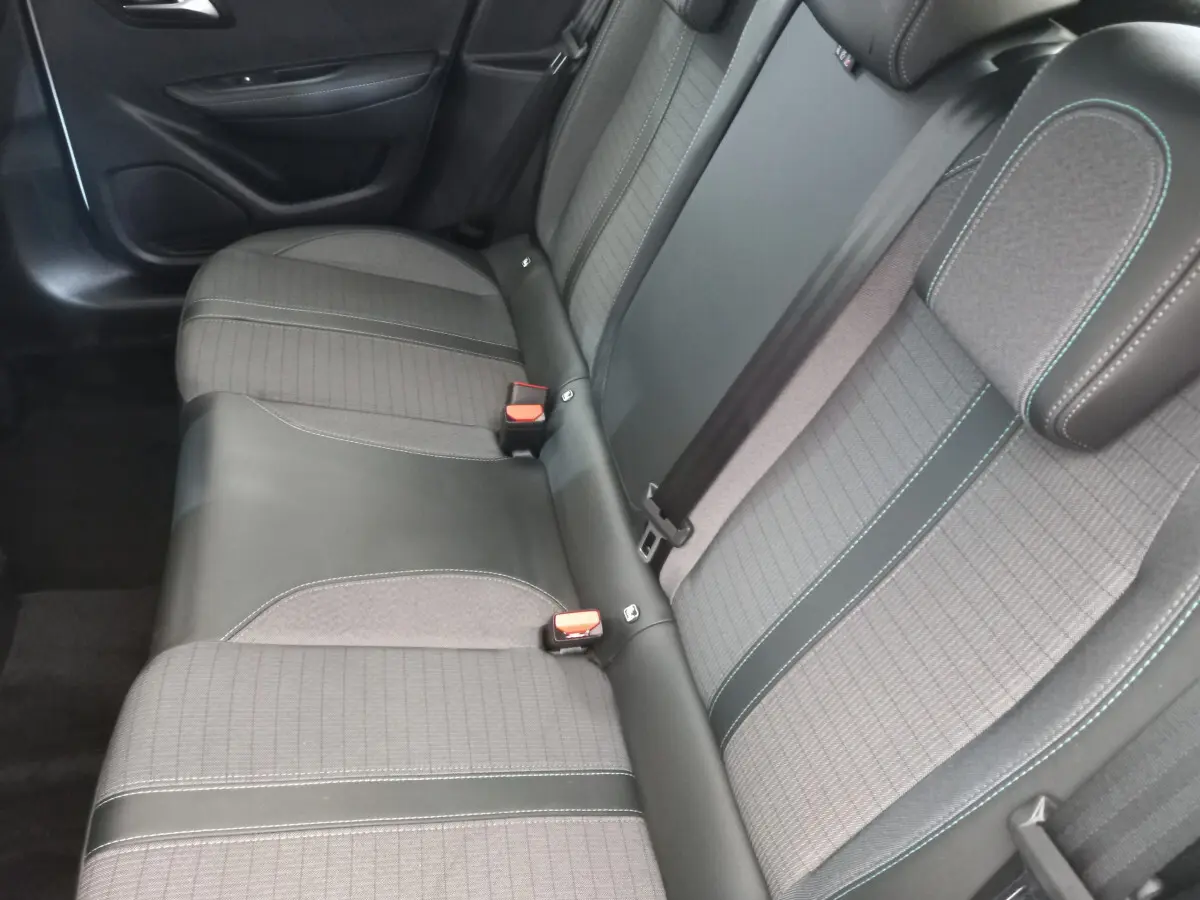 Vue rapprochée de la banquette arrière grise et noire de la Peugeot 208 PureTech 100 S&S Allure 2021, avec ceintures de sécurité visibles.