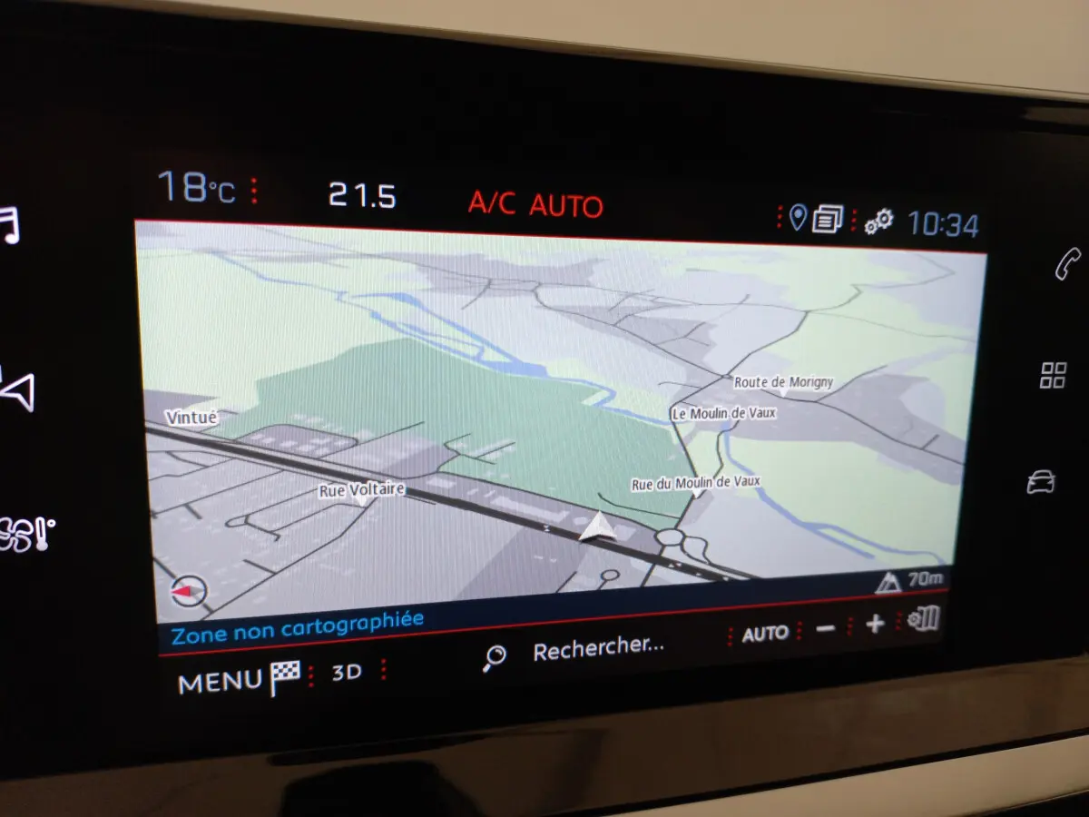 Écran tactile central du tableau de bord de la Peugeot 208 blanc, affichant la navigation GPS en mode 3D.