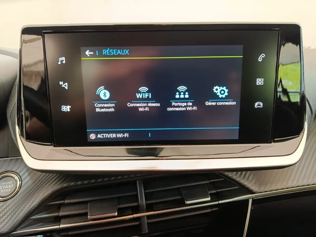 Écran tactile central affichant les options réseau dans l’habitacle d’une Peugeot 208 électrique blanche.