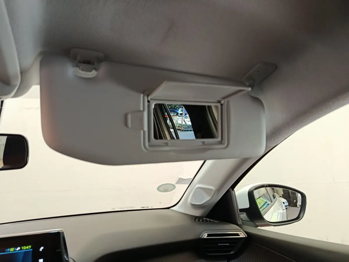 Intérieur de la Peugeot 208 électrique blanc, vue sur pare-soleil avec miroir et rétroviseur côté droit.