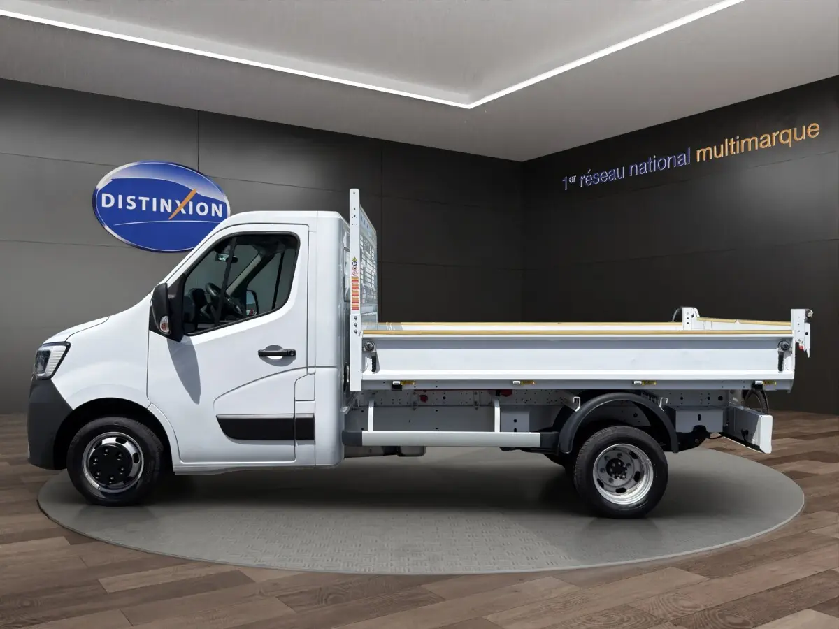 Profil droit d’un utilitaire Renault Master blanc version benne, avec cabine simple et plateau arrière ouvert.