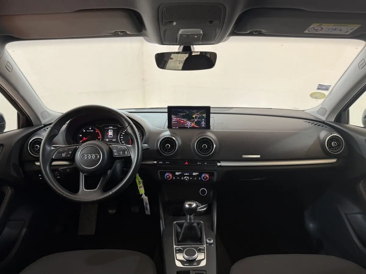 Vue intérieure frontale du tableau de bord noir de l'Audi A3 2.0 TDI 2018 avec écran central et volant cuir multifonctions.