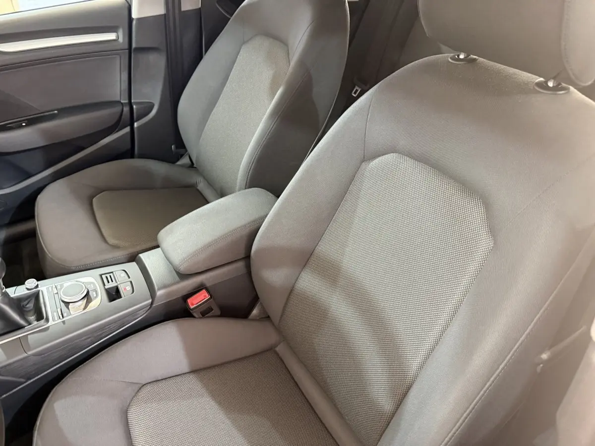 Vue intérieure rapprochée des sièges avant gris foncé et de la console centrale d'une Audi A3 2.0 TDI 2018.