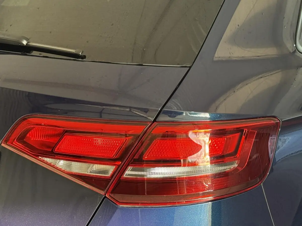 Gros plan sur le feu arrière droit rouge d'une Audi A3 bleu métallisé, soulignant les lignes nettes du hayon.