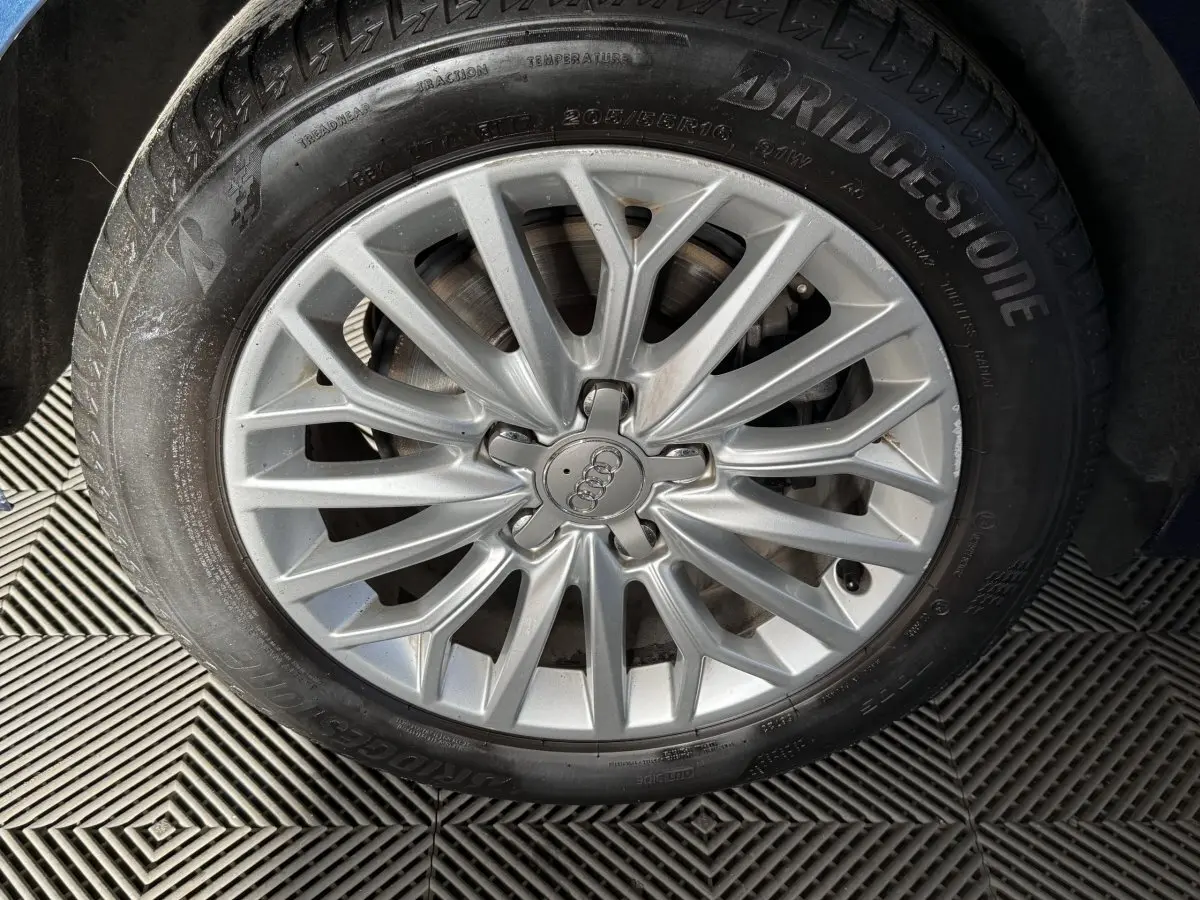 Gros plan sur la jante alliage argentée et pneu Bridgestone d'une Audi A3 2.0 TDI 150 Business Line bleu.
