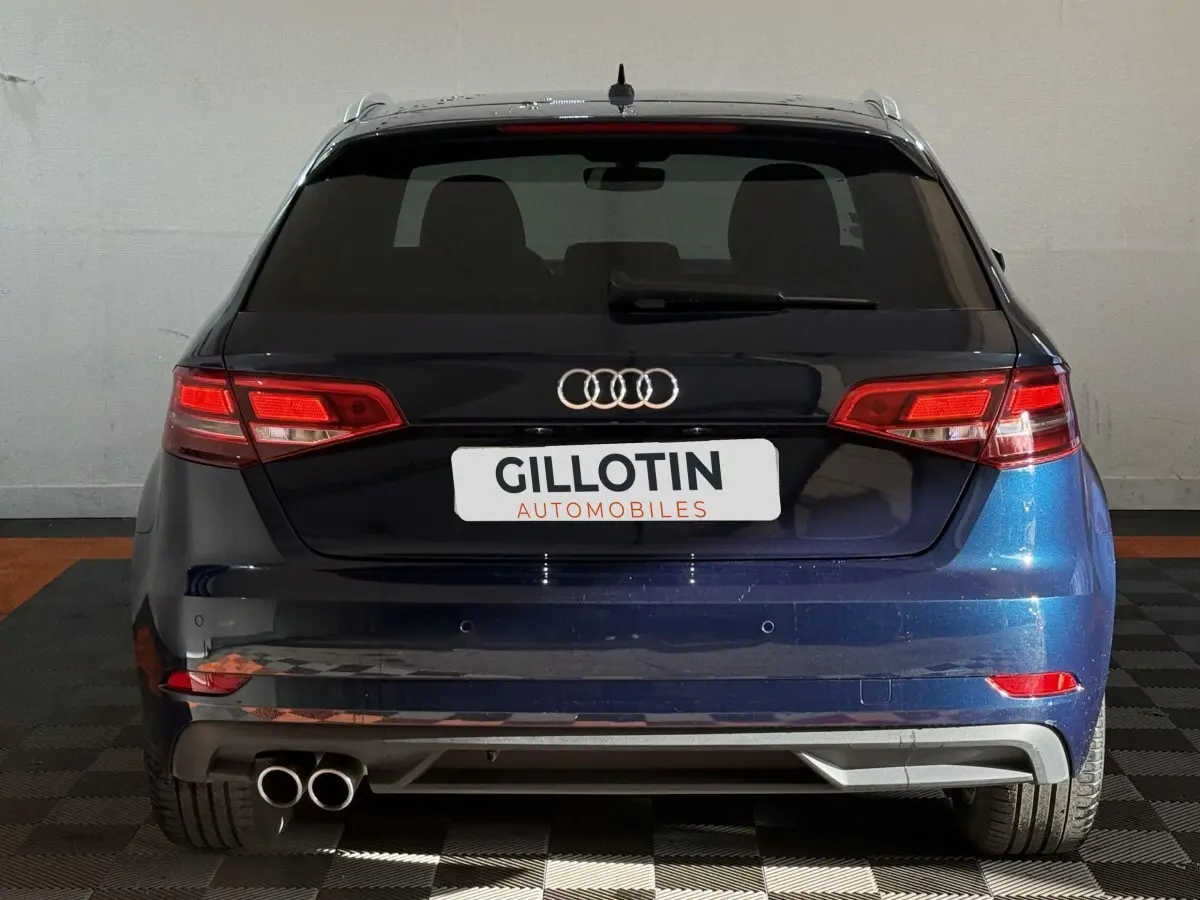 Vue arrière d'une Audi A3 2.0 TDI 150 Business Line bleu, avec feux LED et double sortie d'échappement à gauche.