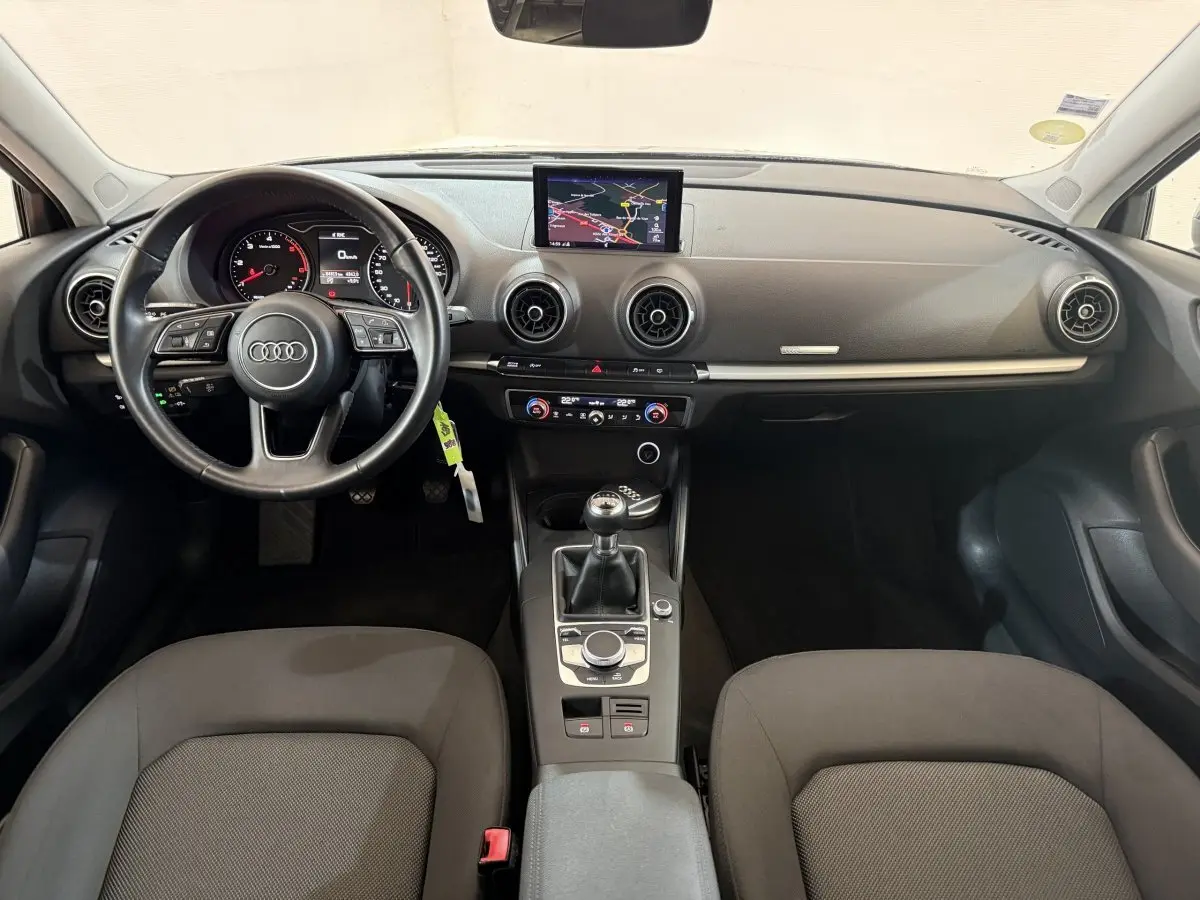 Intérieur Audi A3 2.0 TDI 2018 vu de face, tableau de bord noir avec écran navigation et boîte manuelle.