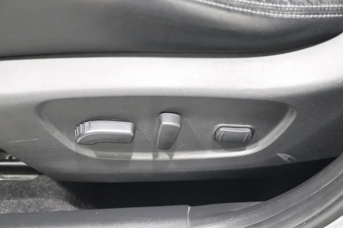 Gros plan sur les commandes de réglage électrique du siège conducteur en cuir noir du Nissan X-TRAIL 2021.