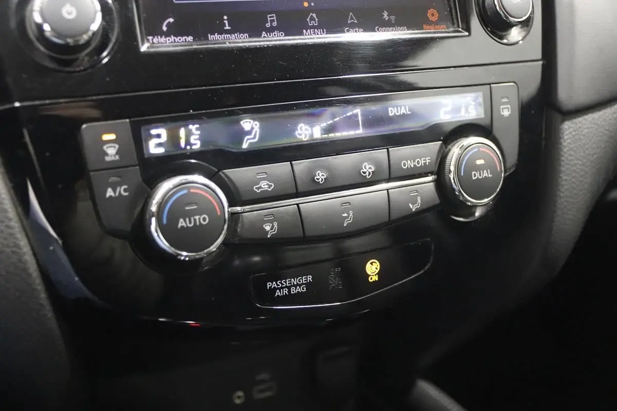 Gros plan sur la console centrale du Nissan X-TRAIL 1.7 D 150, affichant la climatisation digitale à 21,5°C.