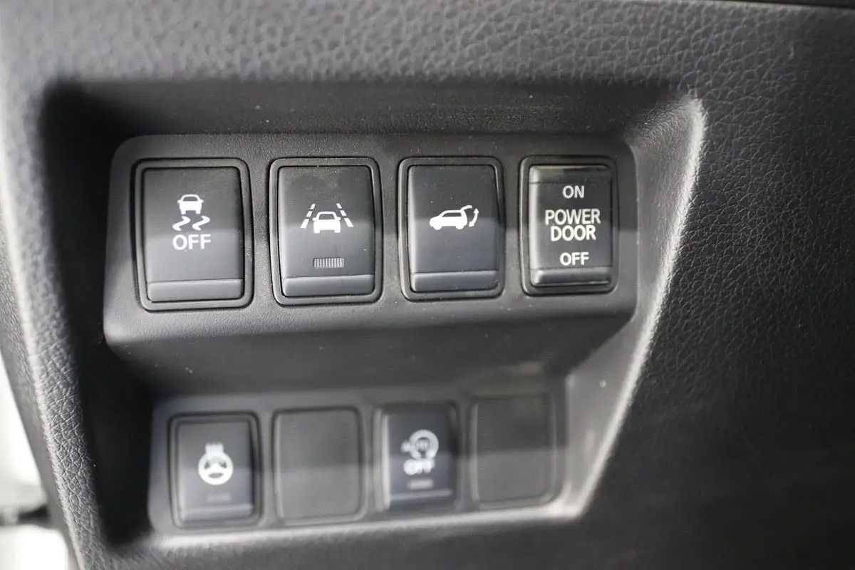 Gros plan sur les boutons de commande noirs du tableau de bord du Nissan X-TRAIL 1.7 D 150 gris métallisé.