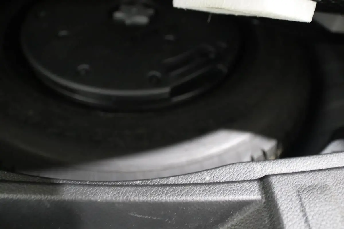 Vue rapprochée de la roue de secours dans le coffre d'un Nissan X-Trail gris métallisé 2021.