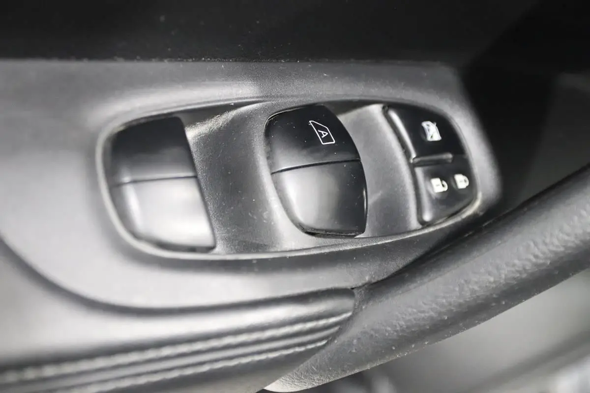 Gros plan sur les commandes de lève-vitres et verrouillage sur la porte intérieure côté conducteur du Nissan X-TRAIL 2021.