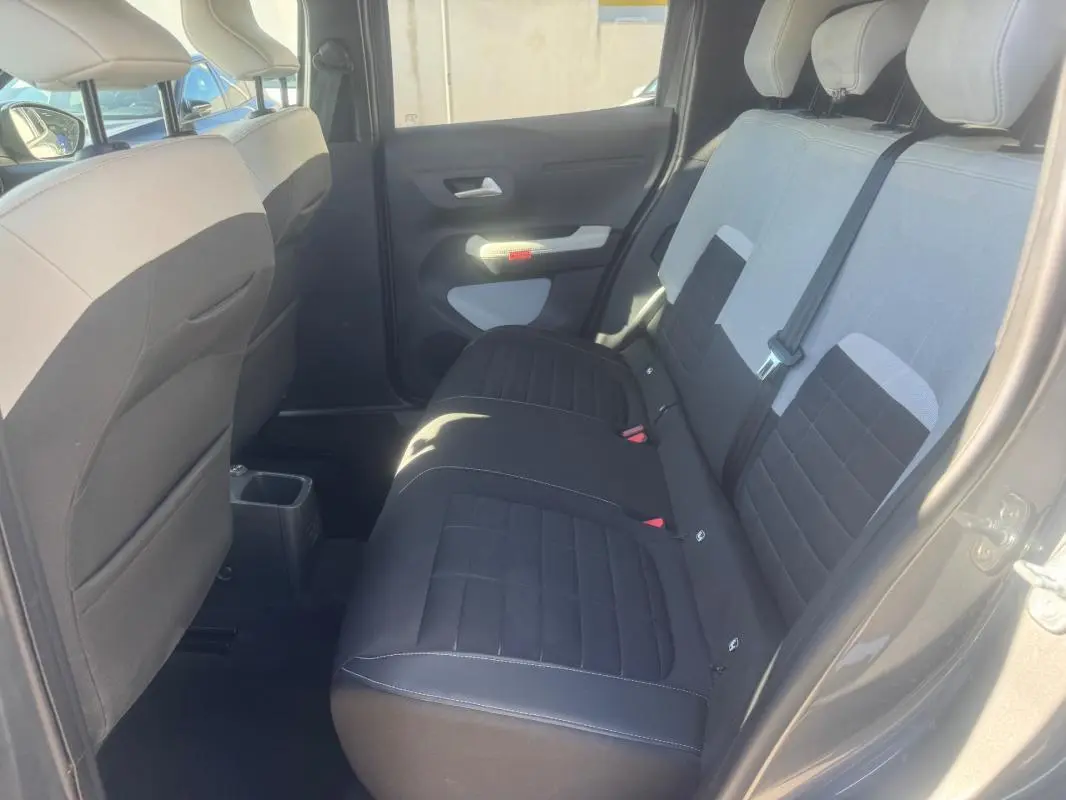 Vue intérieure arrière côté droit de la Citroën C3 gris 2025, montrant les sièges bicolores et les ceintures de sécurité.