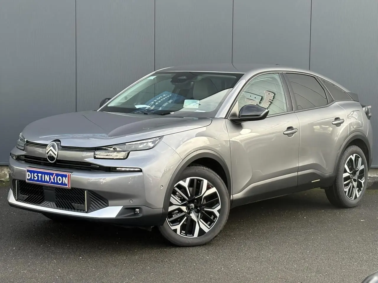 Citroën C4 Hybrid gris Mercury en 3/4 avant droit, avec jantes alliage 18'' et calandre noire distinctive.